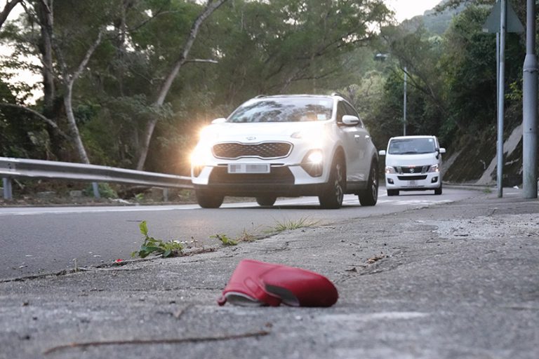記者在一個曾經發生嚴重意外的現場，發現路面上留下一只紅鞋。