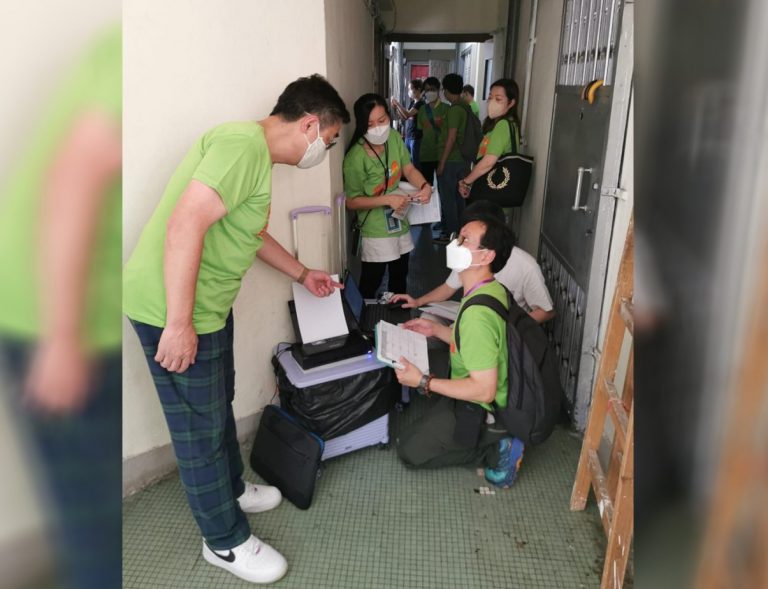 外展團隊身穿綠色制服，帶着疫苗冷凍箱、電腦、打印機及物資箱等出動，為長者打針。