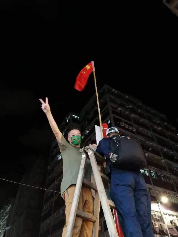 市民幫忙插上國旗和區旗，興奮拍照。