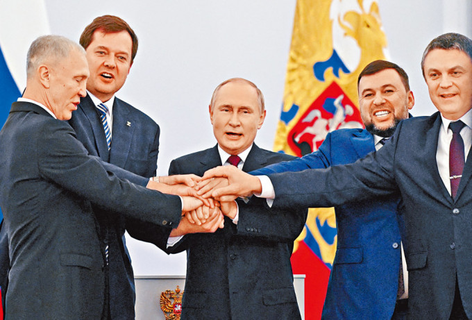 普京在克宮簽署文件後，與頓涅茨克、盧甘斯克、赫爾松和扎波羅熱四區首長手疊手合照。