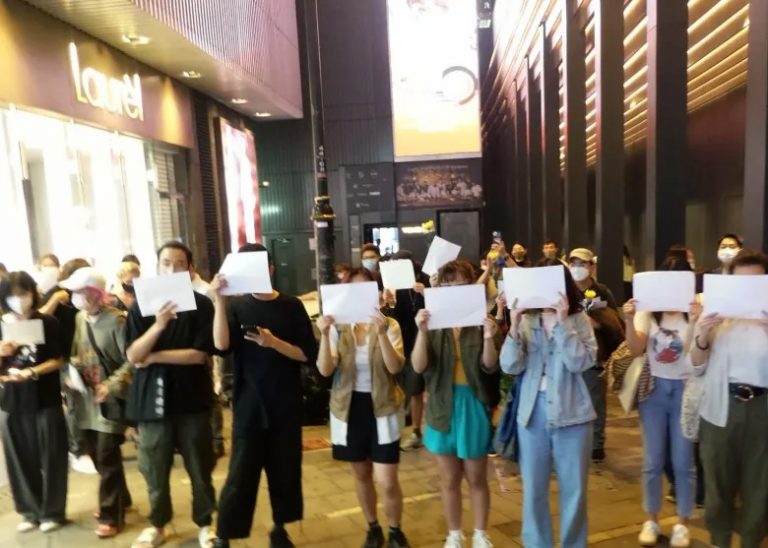 新疆烏魯木齊住宅大火引發內地反封控抗議，香港街頭亦有人聚集舉起紙張悼念。