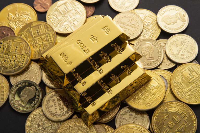 A closeup shot of a pile of shiny gold coins and bars
