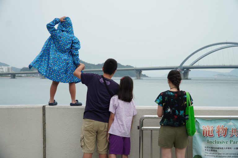 台風前夕，有家長帶同子女在海邊吹風。（燊亮攝）