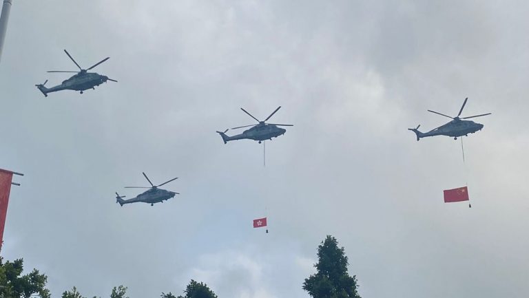 飛行服務隊兩架直升機分別懸掛國旗及區旗飛過維港。