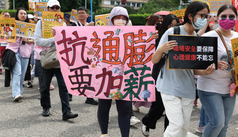 遊行在周四(1日)下午在凱達格蘭大道集結出發,有人自製「抗通膨、要加薪」海報到場,盼政府重視改善整體勞動環境。(網上圖片)