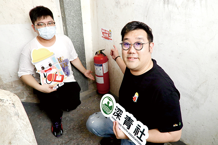 元州街54-56號唐樓住戶Jimmy(左)與深青社項目總監苗凱明合影,他樂見大廈添置了新滅火筒。