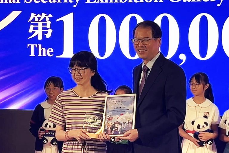維護國家安全委員會秘書長區志光向第100萬名參觀者團體頒發獎狀。