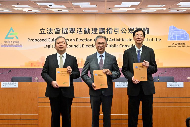 選舉管理委員會主席陸啟康法官(中)、委員石丹理教授(右)和文本立資深大律師(左)在記者會展示立法會選舉活動建議指引的公眾諮詢文件。 (政府新聞處)