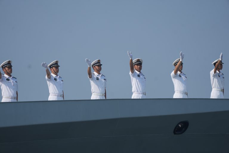 艦上官兵揮手向送別人士致意。