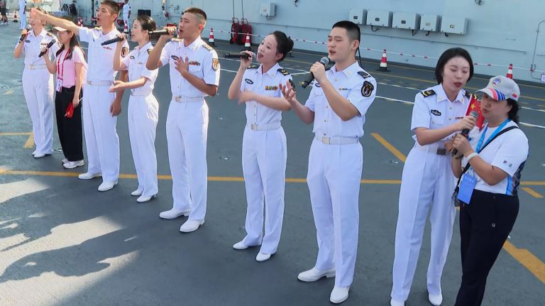登上山東艦參觀的市民,與軍樂隊合唱愛國歌曲。